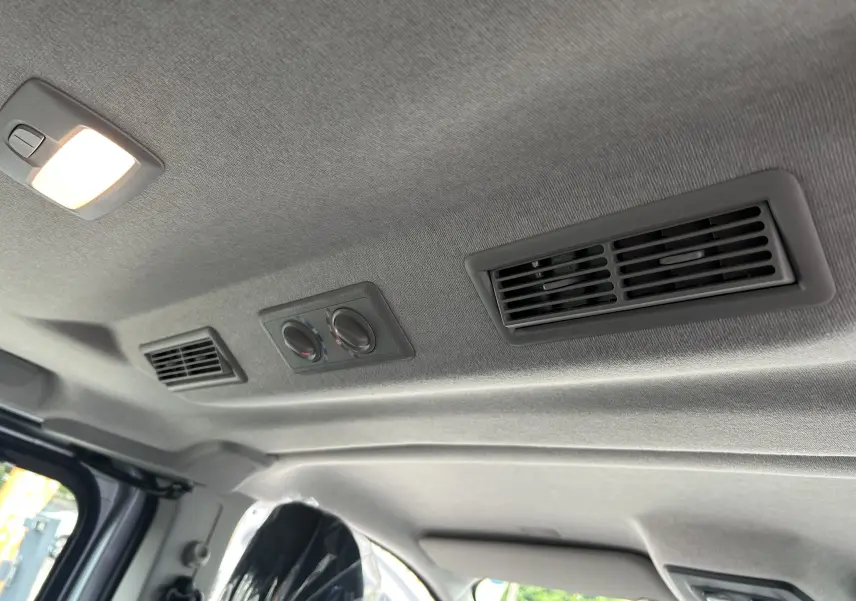 Plafond intérieur gris du Renault Trafic Combi L2 Grand Evolution 2025 avec aérateurs et commandes de climatisation arrière.