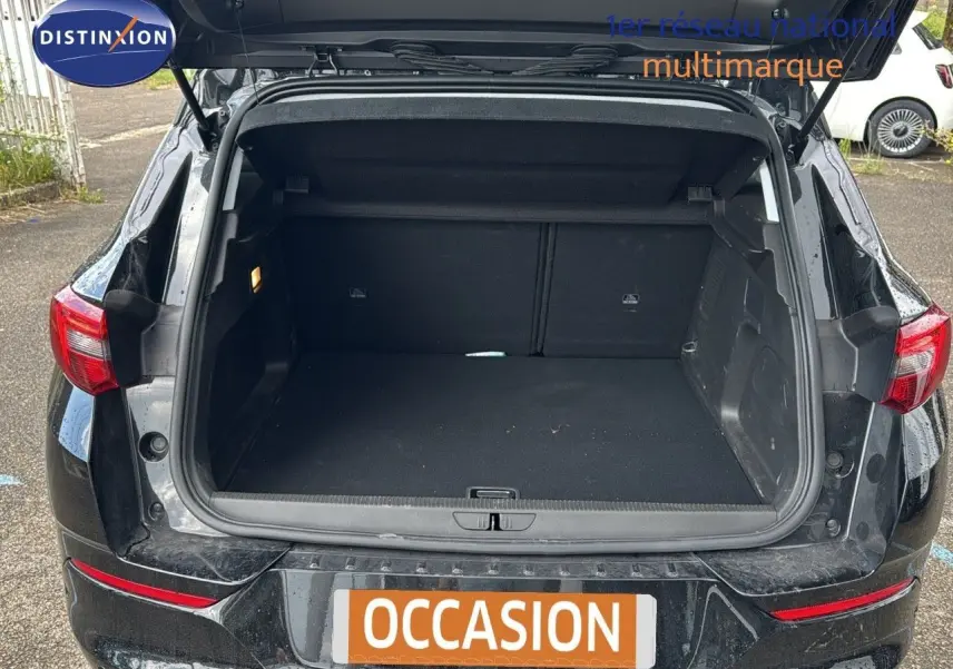 Coffre ouvert d’un Opel Grandland noir 2024 vu de l’arrière, montrant un espace de chargement spacieux et propre.