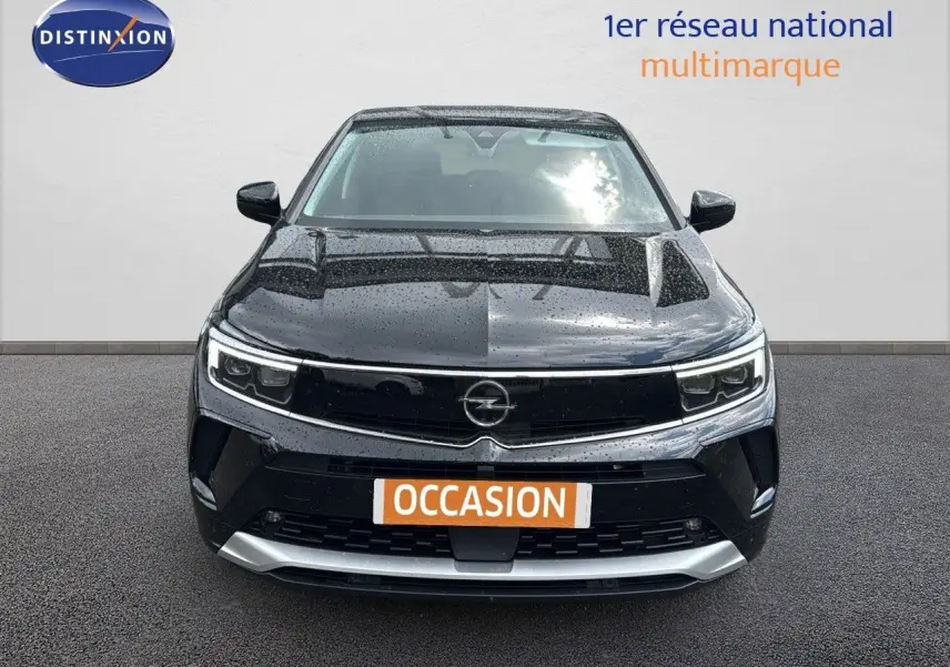 Vue de face d'un Opel Grandland 1.6 Turbo Hybrid 225ch GS noir, avec calandre et phares LED sous la pluie.