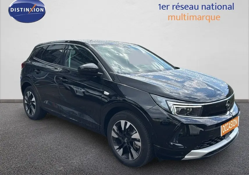 Opel Grandland noir en 3/4 avant droit, hybride rechargeable, jantes bi-ton et calandre chromée visible.