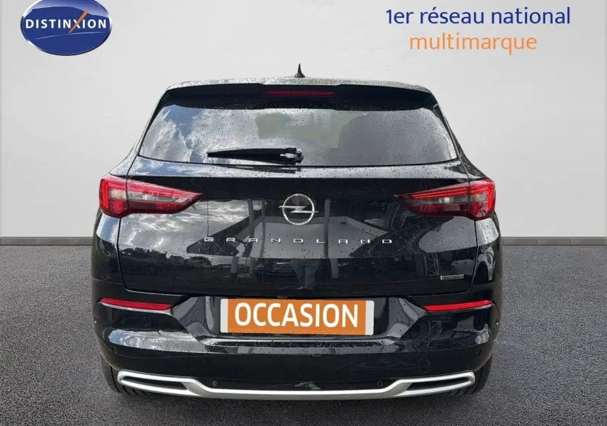 Vue arrière d'un Opel Grandland noir 2024 avec feux LED et logo distinctif sur un fond neutre.