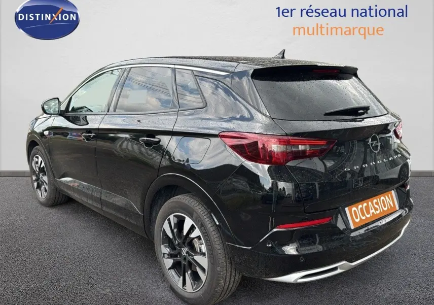 Opel Grandland noir vue 3/4 arrière droit, hybride rechargeable, jantes bi-ton et feux arrière LED visibles.