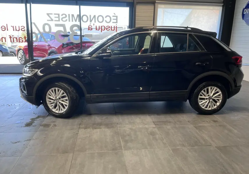 Profil côté gauche d'un Volkswagen T-Roc 2025 noir Deep Black Pearlescent avec jantes alliage et vitres teintées.