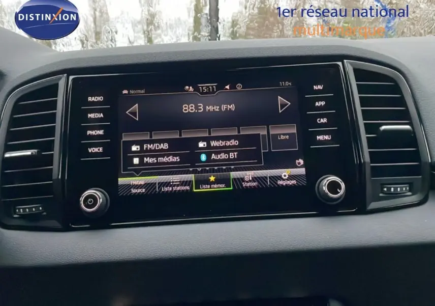 Écran tactile central du Skoda Karoq 2025 affichant les options radio et médias, entouré de commandes noires.