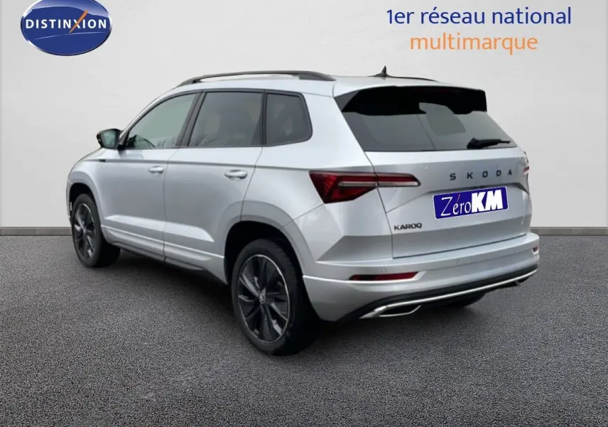 Vue 3/4 arrière droite d’un Skoda Karoq gris argent métallisé avec jantes noires et vitres teintées.