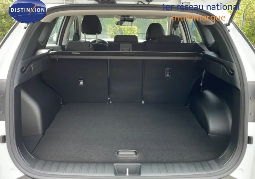 Coffre ouvert d’un Hyundai Tucson blanc Atlas 2026, montrant un espace de chargement propre et spacieux avec cache-bagages.