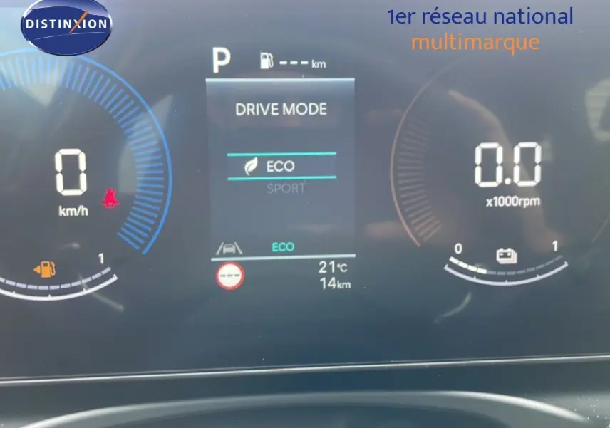 Tableau de bord numérique du Hyundai Tucson blanc, affichant le mode de conduite ECO et compte-tours à l'arrêt.