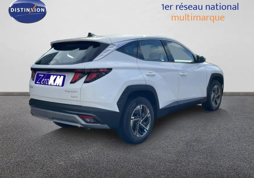 Vue 3/4 arrière droite du Hyundai Tucson blanc Atlas 2026 avec feux arrière LED et jantes bi-ton.