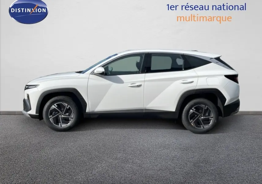 Vue de profil côté gauche d'un Hyundai Tucson blanc Atlas 2026 avec jantes bi-ton et lignes anguleuses marquées.