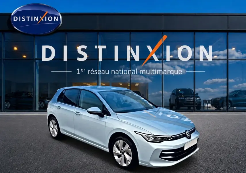 Volkswagen Golf bleu glacier vue 3/4 avant droit devant showroom Distinxion, jantes alu 17 pouces visibles.