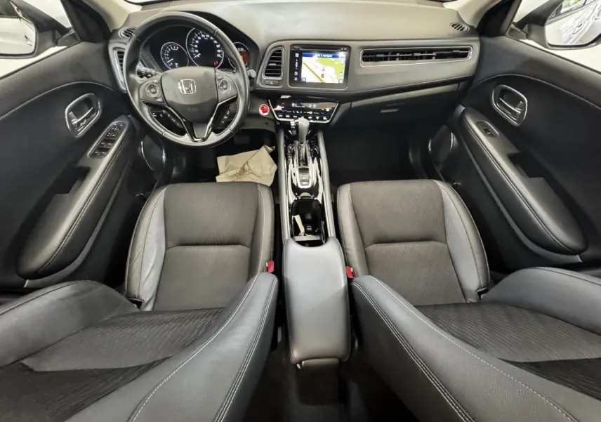 Vue intérieure frontale du Honda HR-V 1.5 i-VTEC 130 Exclusive, tableau de bord avec écran tactile et volant multifonctions noir.