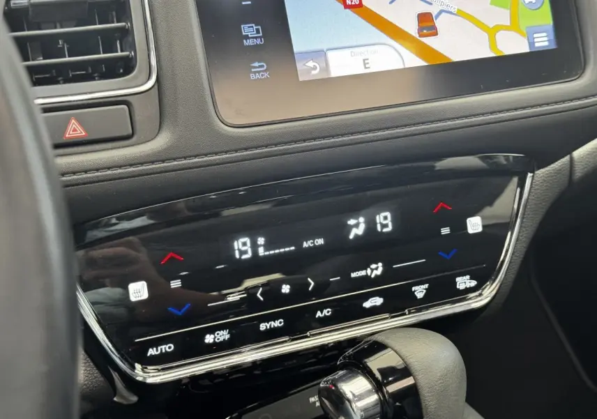 Détail de la console centrale du Honda HR-V blanc 2019, montrant l'écran tactile de navigation et la commande de climatisation digitale.