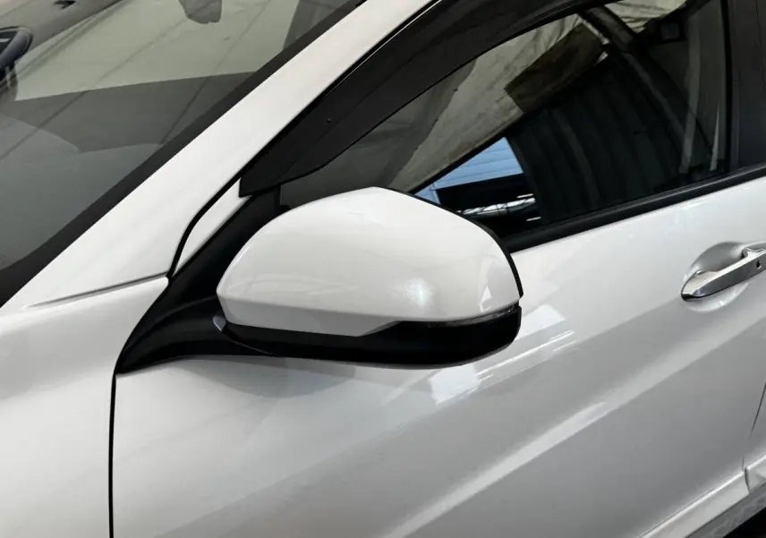 Rétroviseur côté conducteur blanc avec clignotant intégré sur Honda HR-V 1.5 i-VTEC 130 Exclusive blanc, vue latérale.