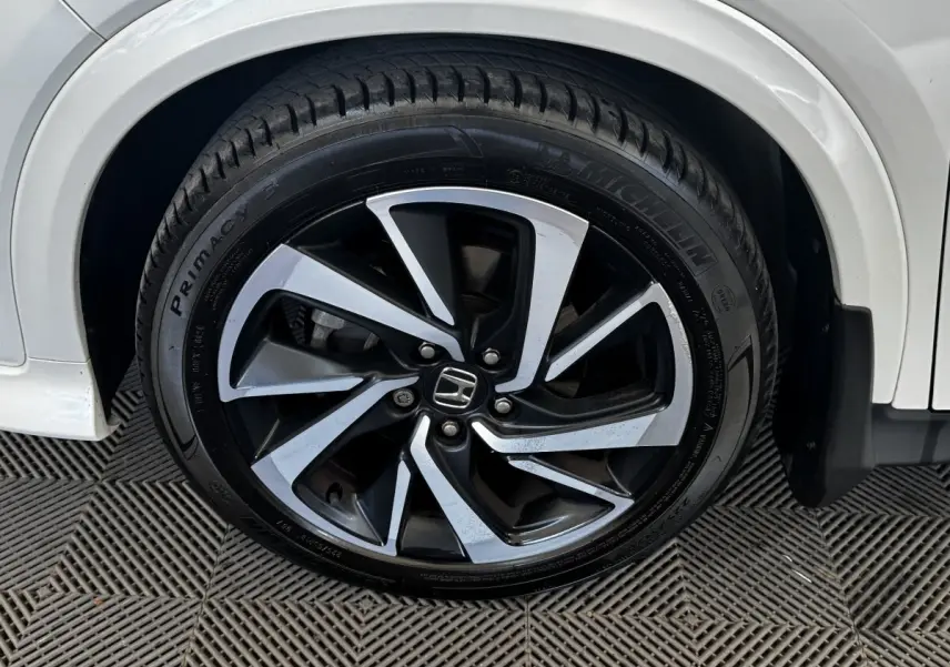 Gros plan sur la roue avant droite du Honda HR-V blanc 2019, jante alliage bicolore et pneu Michelin.