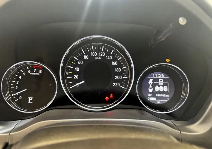 Vue rapprochée du tableau de bord du Honda HR-V blanc, affichant la vitesse, le compte-tours et un écran digital multifonctions.