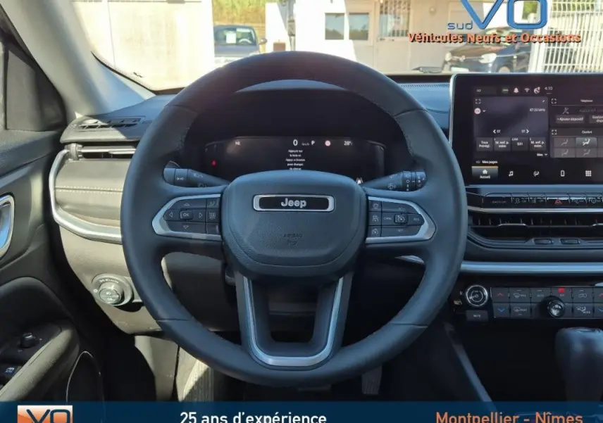 Vue frontale du volant Jeep Compass gris 2024 avec tableau de bord numérique et écran tactile central.