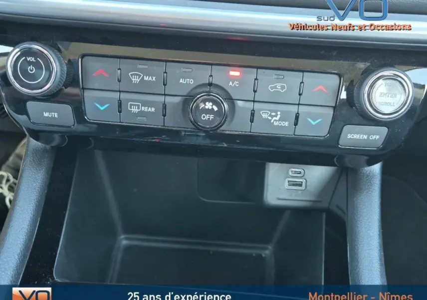 Vue rapprochée de la console centrale du Jeep Compass 2024, avec commandes climatisation et ports USB visibles.