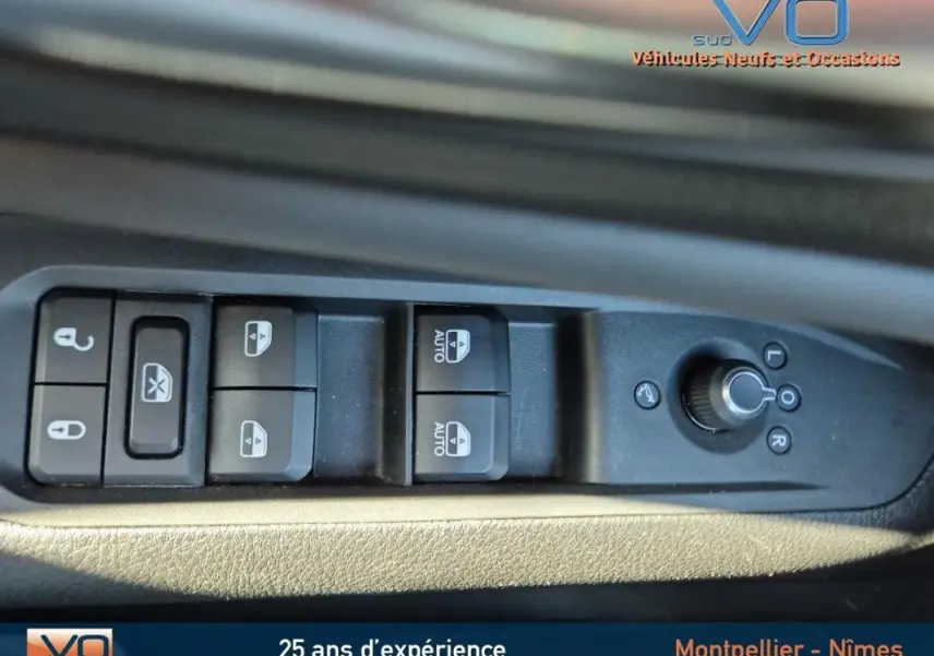 Commandes des vitres et rétroviseurs électriques sur la portière côté gauche d'un Jeep Compass gris 2024.