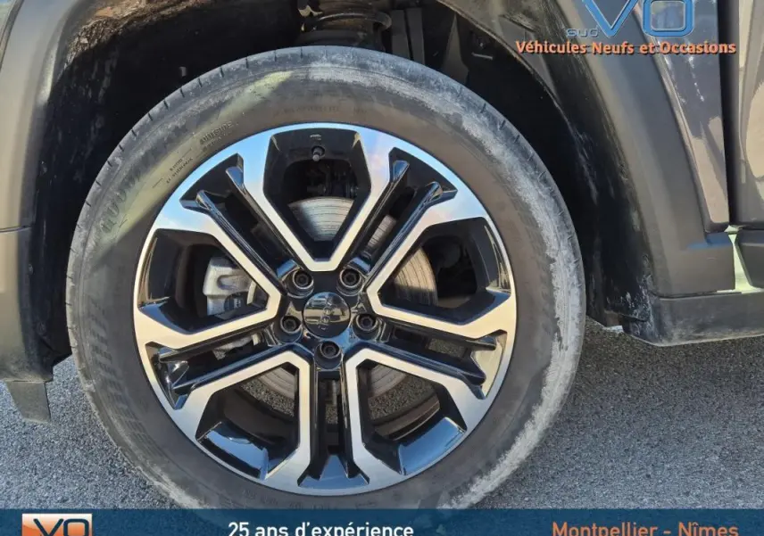 Gros plan sur la jante alliage 18 pouces noire et argent du côté avant droit du Jeep Compass gris 2024.