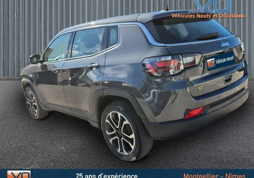 Jeep Compass gris en 3/4 arrière droit, jantes alliage 18 pouces et feux arrière LED visibles.