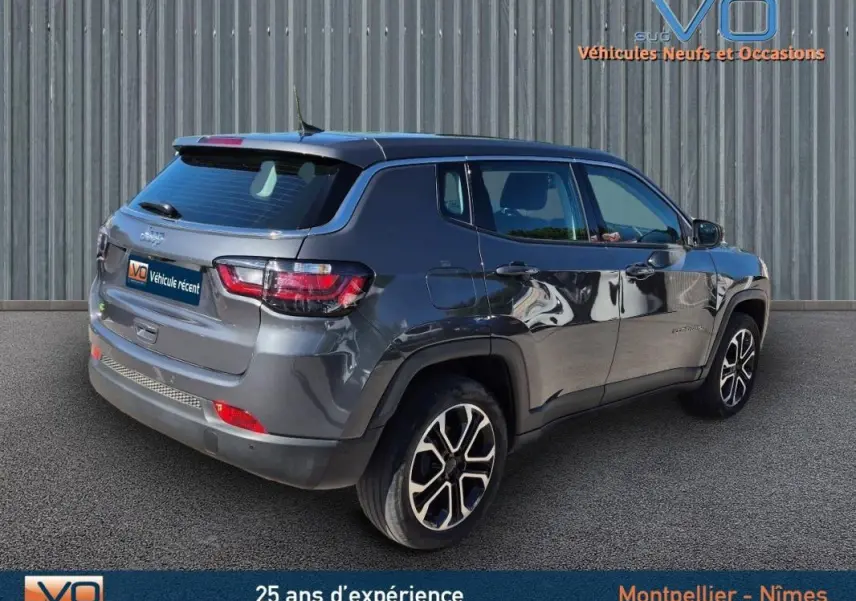 Jeep Compass gris 3/4 arrière droit, jantes alliage 18 pouces, SUV compact 2024 avec feux LED et toit noir.