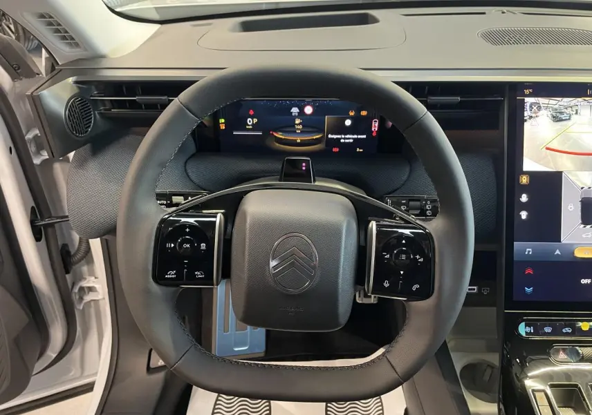 Vue intérieure centrée sur le volant noir du Citroën C5 Aircross 2026 avec tableau de bord numérique et écran tactile.