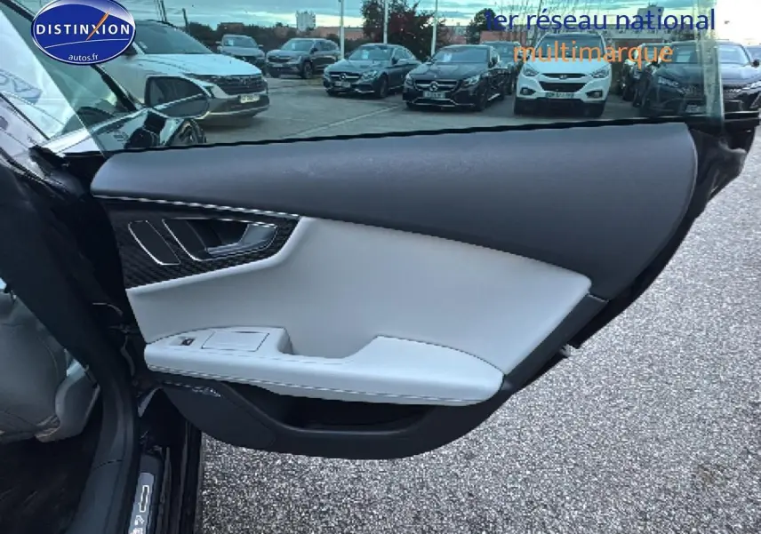 Vue intérieure de la porte avant gauche noire de l'Audi S7 Sportback avec garniture claire et insert carbone.