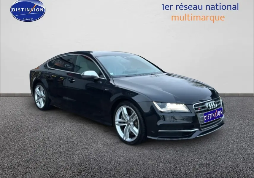 Audi S7 Sportback noir vue 3/4 avant droit, jantes alu et calandre chromée brillante sur fond neutre.