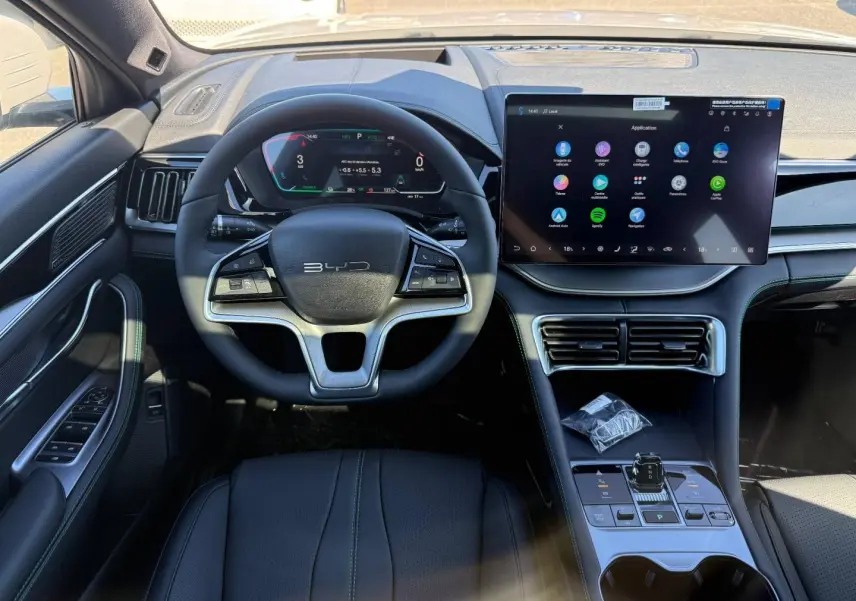 Vue intérieure frontale du poste de conduite BYD SEAL U 2026 avec volant multifonction, écran tactile large et console centrale épurée.