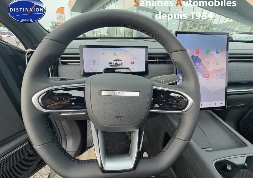 Vue intérieure centrée sur le volant du JAECOO J7 1.5 PHEV Exclusive avec tableau de bord numérique et écran tactile vertical.