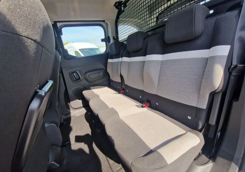Vue intérieure côté droit des sièges arrière gris clair et foncé du Citroën Berlingo 2025 avec grille de séparation.