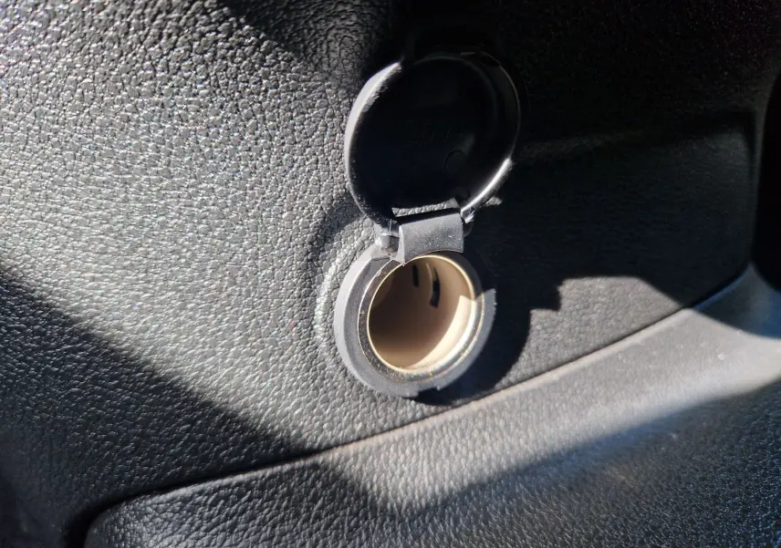Prise 12V ouverte sur le tableau de bord noir texturé du Citroën Berlingo M 1.5 BlueHDi 2025.