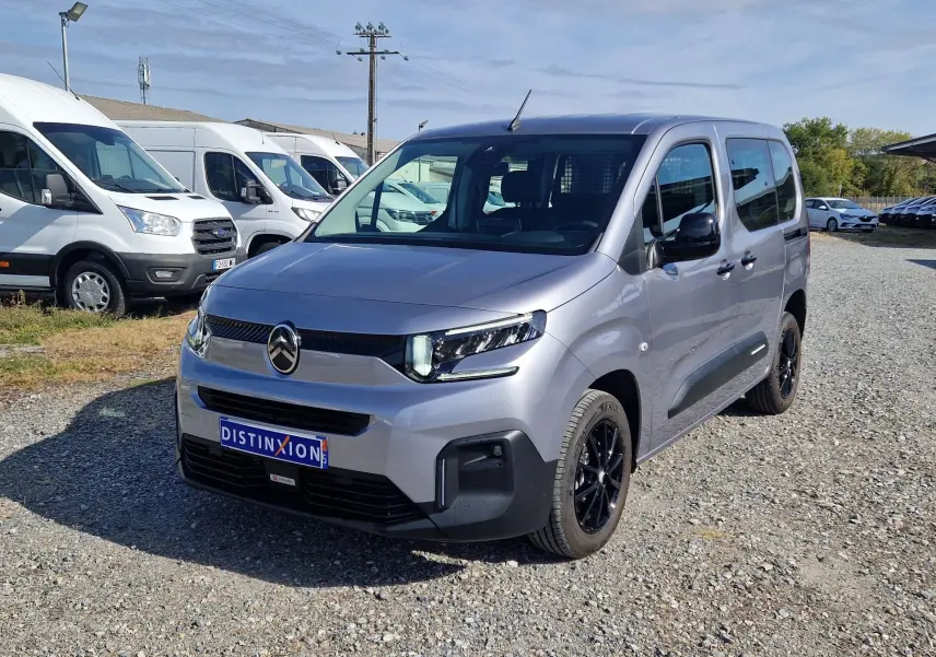 Citroën Berlingo gris Artense en 3/4 avant droit, avec jantes noires et calandre moderne, sur parking extérieur.