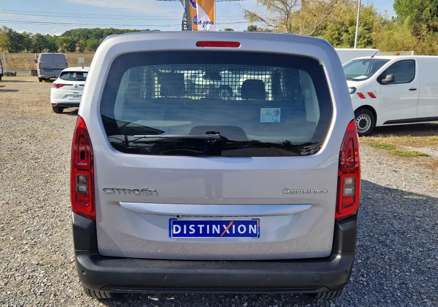 Vue arrière d'un Citroën Berlingo gris Artense 2025 avec grille de séparation et feux rouges verticaux.