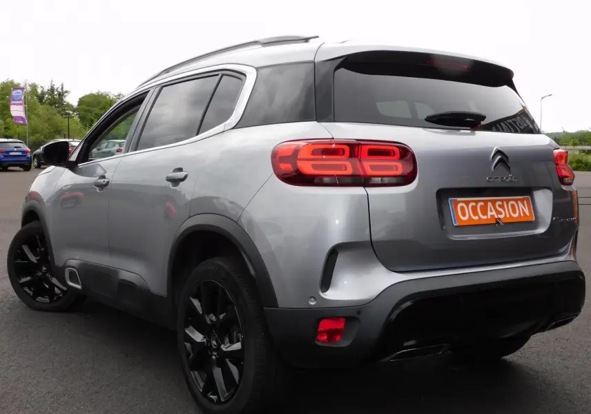 Vue 3/4 arrière droite d'un Citroën C5 Aircross gris avec feux arrière LED et jantes alliage noires.