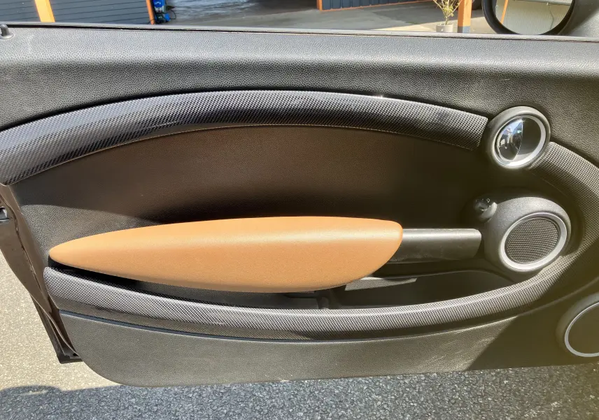 Gros plan sur la garniture intérieure marron et noire de la porte côté gauche d'une MINI Cooper S R56 de 2012.