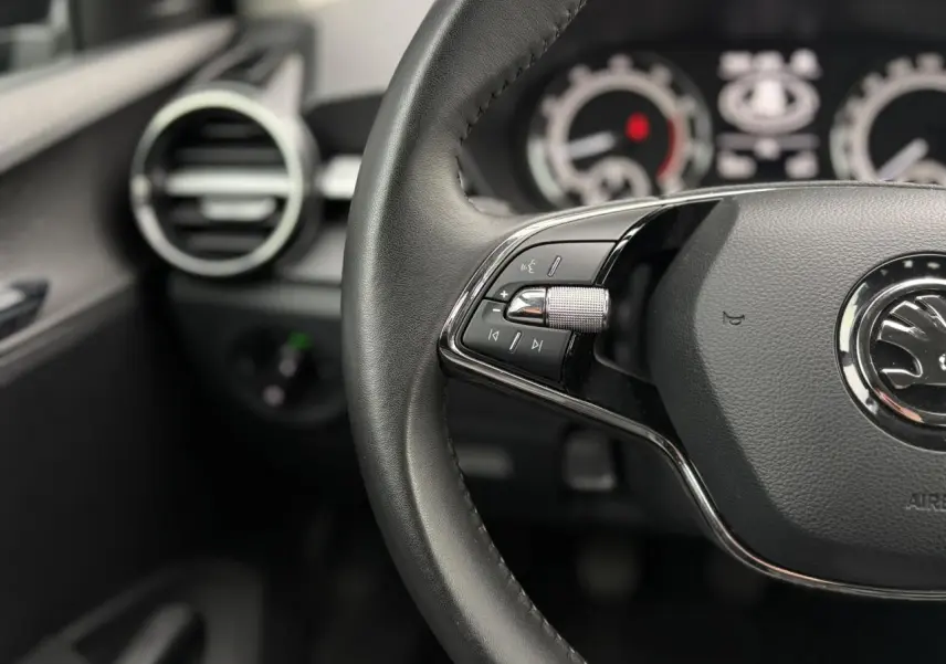 Vue 3/4 arrière droite d'une Skoda Fabia 2024 noir Magic avec feux arrière LED et jantes acier.
