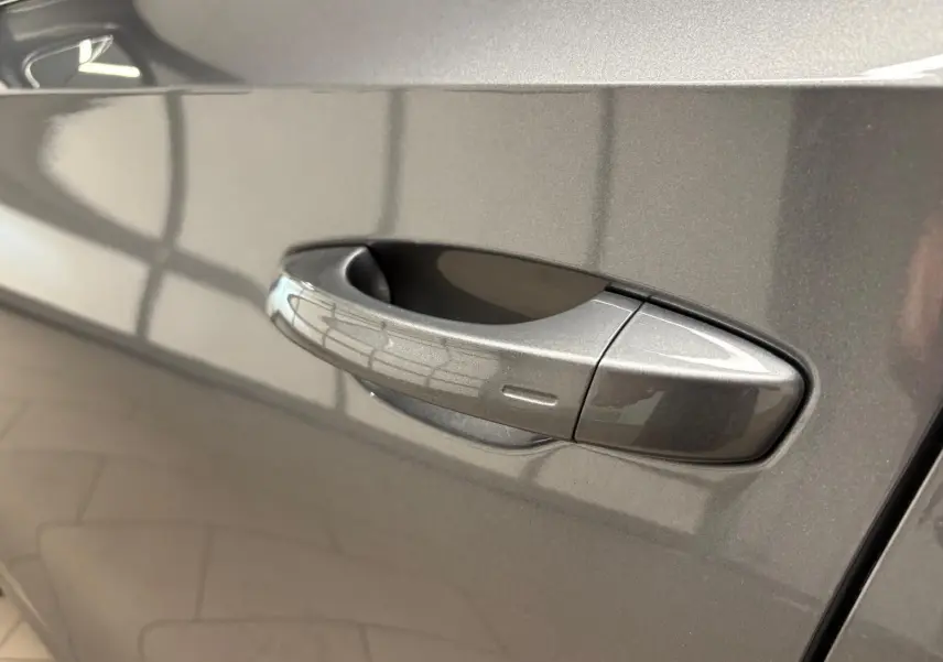 Poignée de porte côté gauche de la Skoda Fabia 2023 en gris graphite métallisé, vue rapprochée sur la carrosserie lisse.