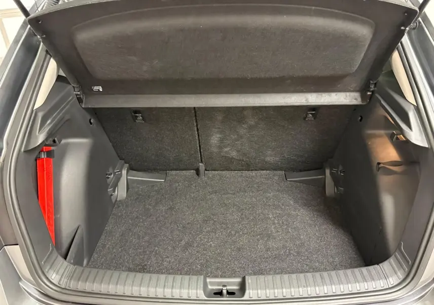 Coffre ouvert de la Skoda Fabia 2023 gris graphite, vue intérieure montrant l’espace de chargement et les garnitures noires.