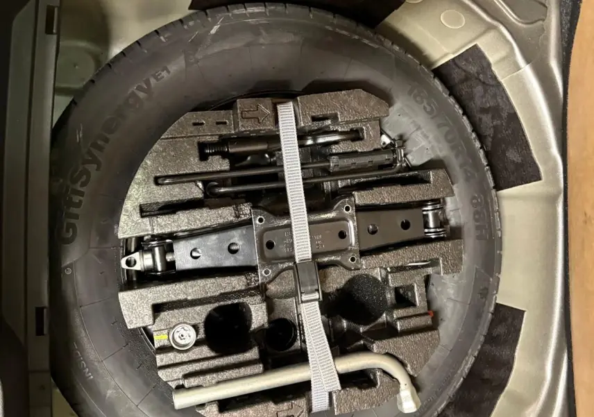 Gros plan sur la roue de secours et les outils de bord dans le coffre de la Skoda Fabia 2023 Gris Graphite.