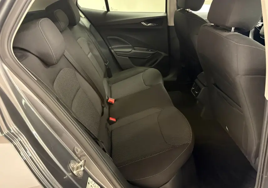 Vue intérieure sur les sièges arrière noirs d’une Skoda Fabia 2023, porte ouverte côté gauche, tissu avec surpiqûres visibles.