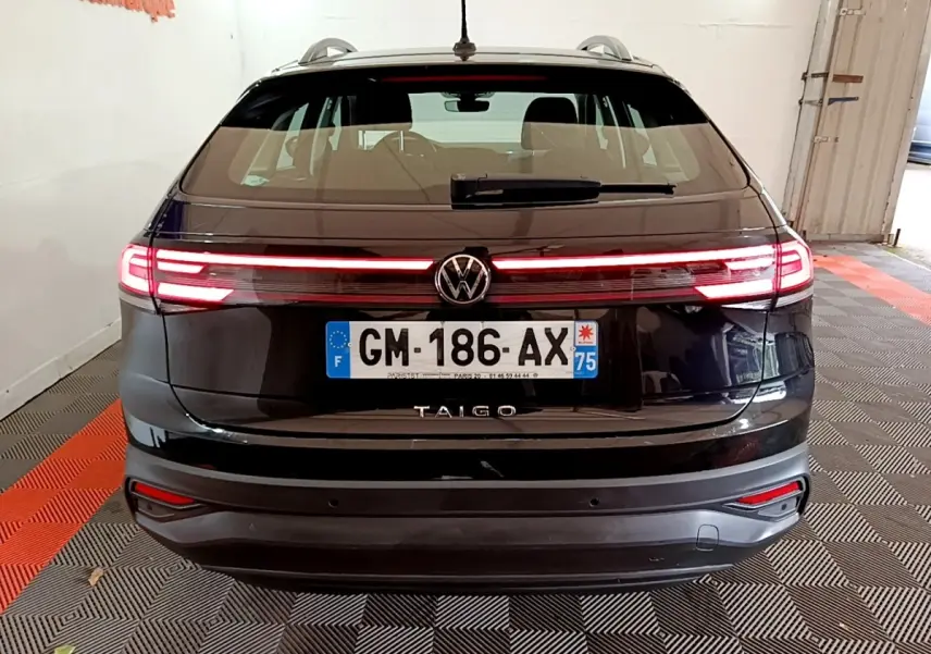 Vue arrière d’un Volkswagen Taigo noir 2023 avec feux LED allumés et plaque d’immatriculation française visible.