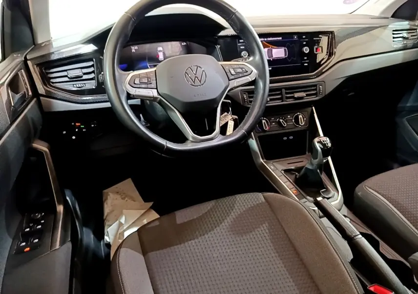 Vue intérieure du tableau de bord et volant cuir noir du Volkswagen Taigo 1.0 TSI 95 Life 2023 avec boîte manuelle.