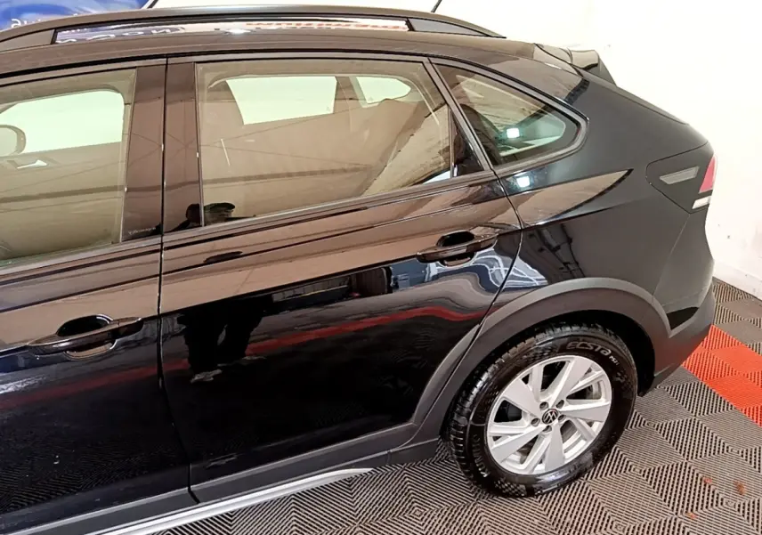 Vue latérale côté droit du Volkswagen Taigo noir 2023, mettant en valeur la porte arrière et la roue arrière.