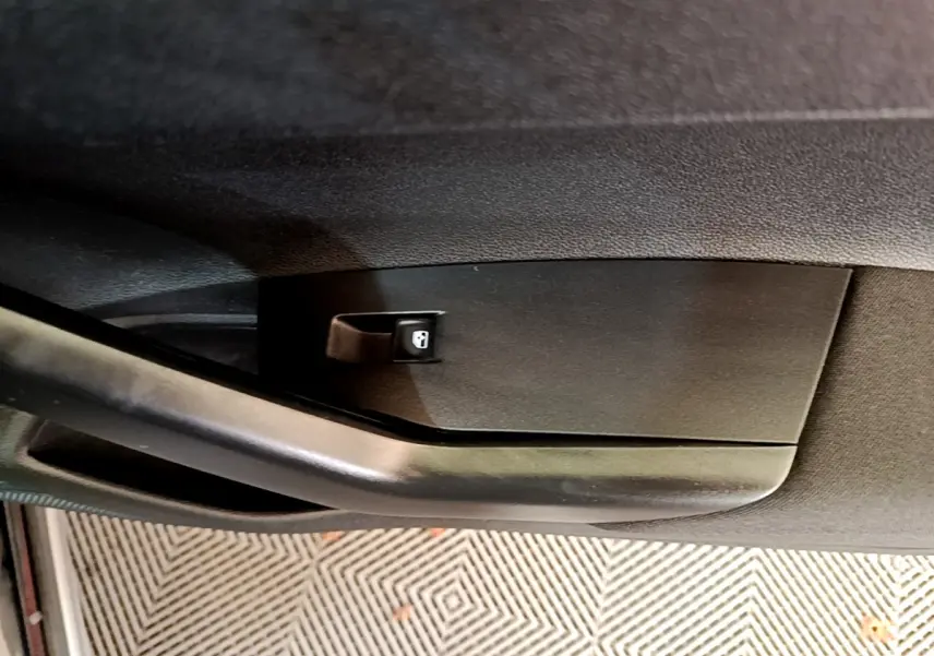 Gros plan sur la poignée intérieure noire de la porte côté conducteur du Volkswagen Taigo 1.0 TSI 95 Life 2023.