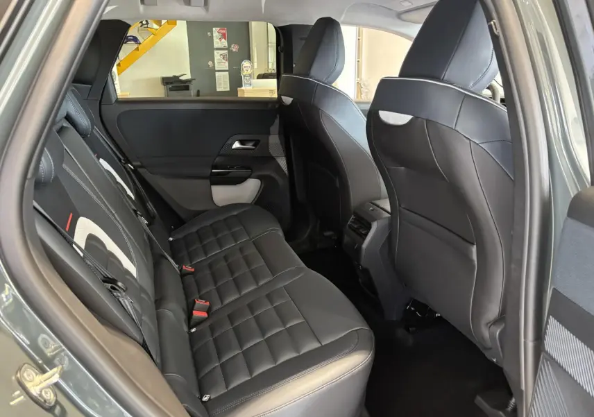 Vue intérieure côté gauche de la banquette arrière en cuir noir du Citroën C5 Aircross vert 2026, avec appuis-tête et portières visibles.