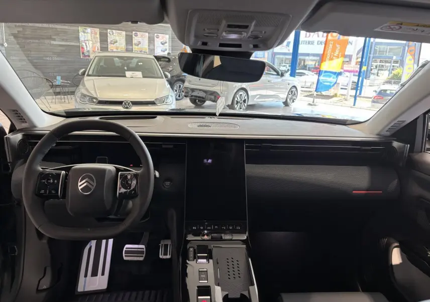 Vue intérieure avant du Citroën C5 Aircross 2026, tableau de bord noir avec écran tactile vertical et volant multifonctions.