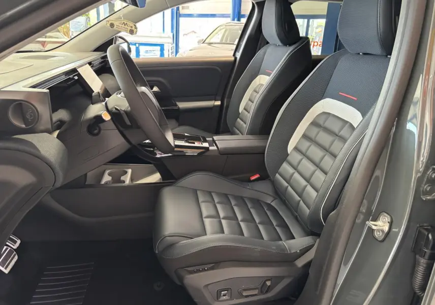 Vue intérieure côté conducteur du Citroën C5 Aircross vert, sièges cuir noir avec inserts gris et rouge, volant multifonctions.