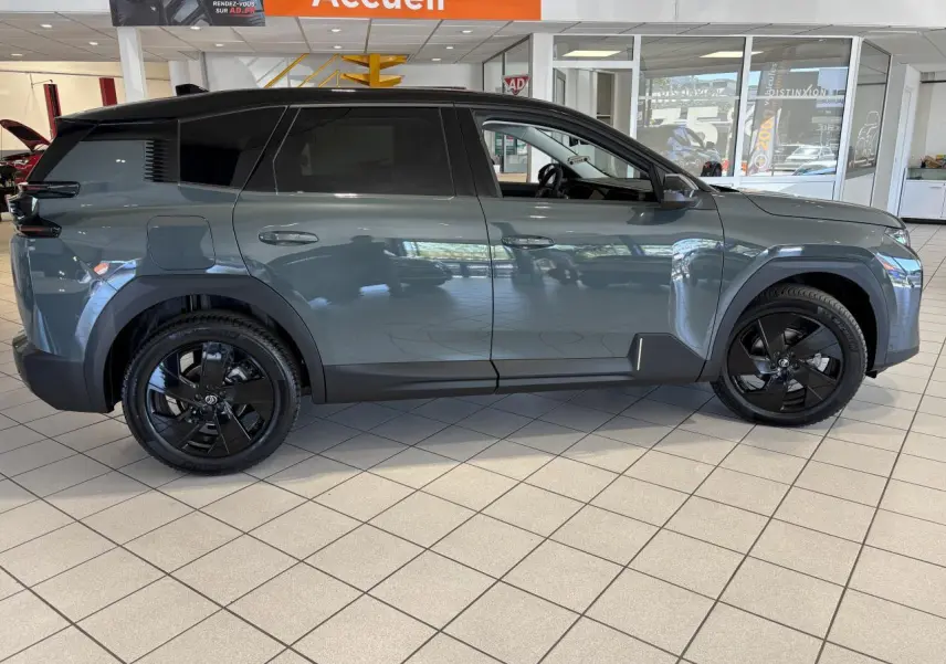 Vue de profil côté gauche du Citroën C5 Aircross vert métallisé avec jantes alliage noires en showroom.