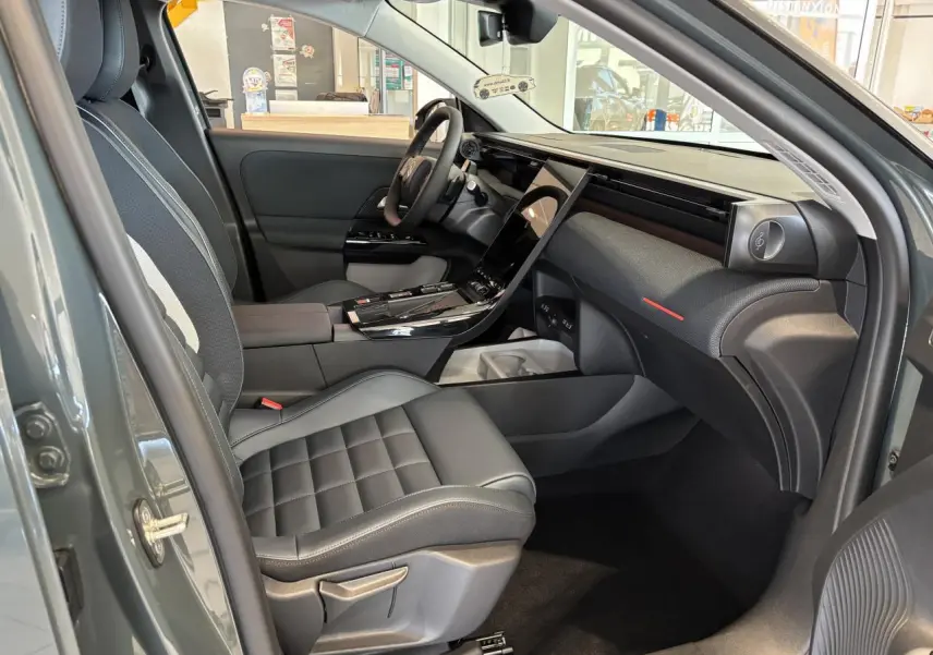 Vue intérieure côté passager avant du Citroën C5 Aircross vert, avec sellerie noire et tableau de bord moderne.